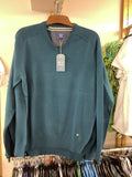 Teal sweatshirt on a mannequin with a tag in a store setting
