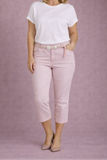 Woman wearing a white t-shirt and pink pants against a pink background