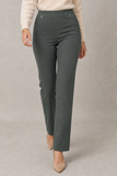 A model wearing a pair of EMRECO high-waisted, straight-leg bengaline trousers in a muted dark khaki color, styled with a cream knit sweater and beige heels against a neutral gray studio background.