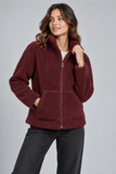 A woman wearing a CLAUDIA C burgundy fleece zip-up jacket with a stand collar and front pockets, paired with dark gray pants, photographed against a solid gray studio background.